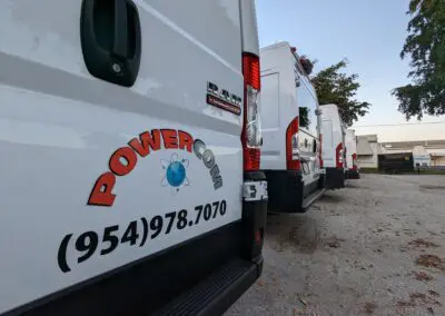 A row of white vans parked in a parking lot.