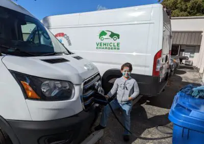 A young boy standing next to a van.