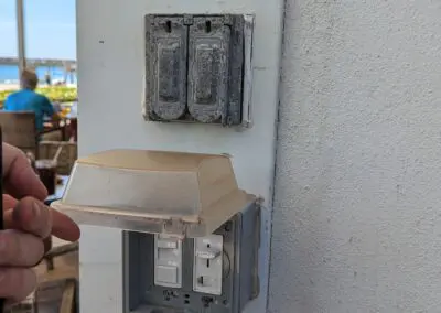 A person is holding a switch on a wall.