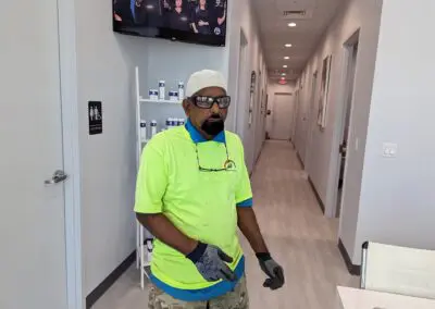 A man in a yellow shirt standing in a hallway.