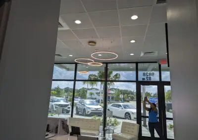 A woman is standing in the lobby of a car dealership.